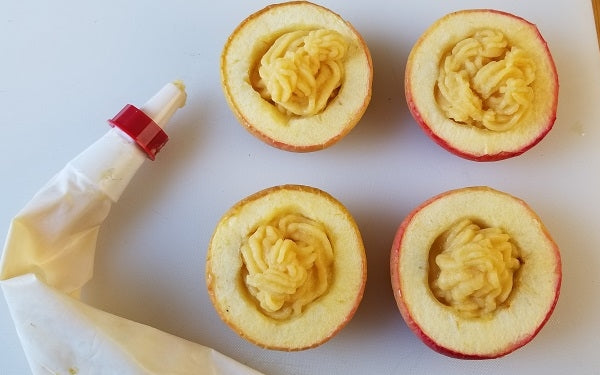 Let the squash mixture cool for a few minutes uncovered before transferring to a food processor, adding the salt and blending until smooth. Transfer the squash mixture to a pastry bag and pipe into the apples.