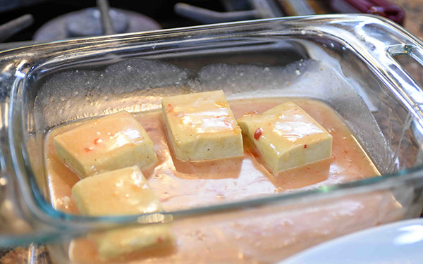 To marinate the tofu, whisk the coconut milk, sweet chili sauce, salt and pepper together and pour over a single layer of the tofu slices. Cover and refrigerate at least 3 hours.