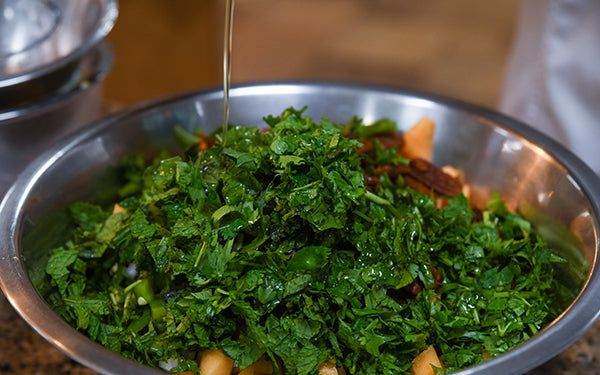 Image of Oil and Vinegar being added to salad/salsa