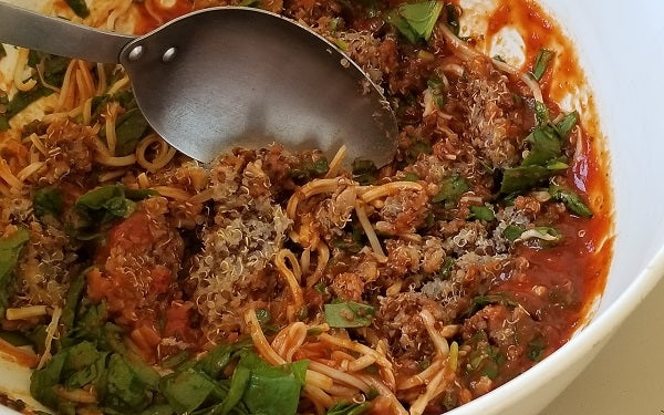 Combine quinoa, marinara sauce, chopped spinach, and a ¼ cup of the cheese in a mixing bowl.