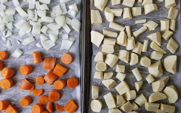 Line two baking sheets with parchment paper. Arrange the chopped parsnips in a single layer on one of the baking sheets; on the other, split the chopped carrots and onion also in a single layer. Roast at 400°F for about 30 minutes or until fork tender. 