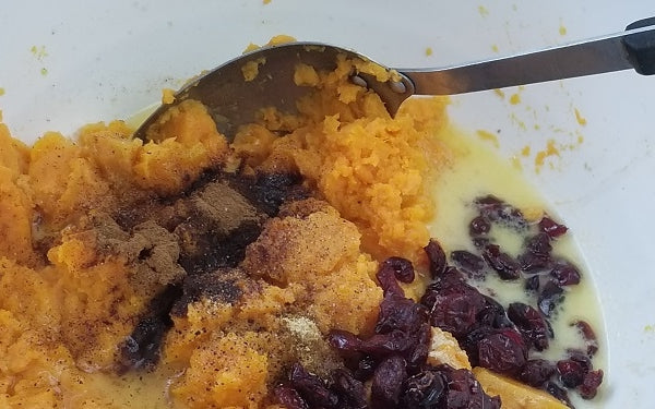 Transfer yams to a mixing bowl and mask to a smooth consistency. Then blend in the milk, 4 tablespoons of the butter, salt, vanilla, ginger, cinnamon, pepper, cranberries. To make ahead: stop here and refrigerate for up to 2 days.