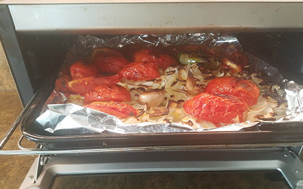 Place veggies in the toaster oven and cook for 11 minutes, or until the tomatoes are lightly charred, then turn tomatoes and continue to cook for another 11 minutes. 