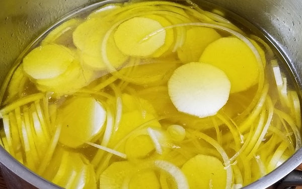 In a large pot, boil sliced daikon in oil and broth until fork-tender, about 10 minutes; drain, discard the onion, and set aside the radish slices. 