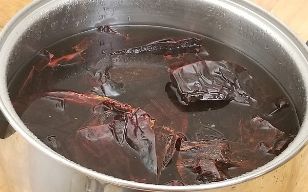 Remove stems and seeds from the dried chile pods. Rinse with cool water. Place the pods in a large sauce pan, filled with enough water to completely cover them.