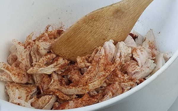 Place the cooked and shredded chicken in a bowl. Mix thoroughly with lime juice and seasonings of choice. Set aside until assembly. 
