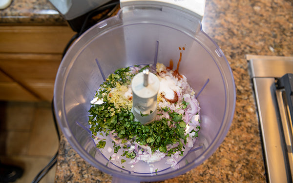 Add the next 10 ingredients to the bowl of a food processor and pulse until the mixture is finely chopped and uniform in size. Transfer to the bowl with the pork and stir well to combine thoroughly. 