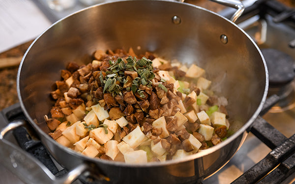 In a stockpot, heat the oil and add in the shallots, Asian pear, celery, celeriac, chestnuts, and sage and cook about 6 minutes. Add in the garlic and cook another minute.