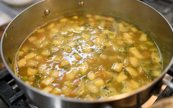 Add in the vegetable stock, bring the mixture to a boil, and then reduce the heat to medium-high.