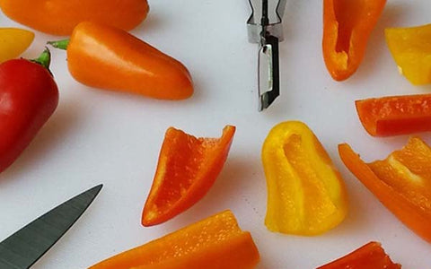 Image of Prepare the peppers by cutting off the stems, then cut the peppers in half, lengthwise. Trim or pull out the white membrane and seeds