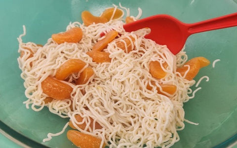 Image of mixing noodles with tangerine segments