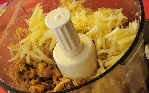 Image of adding shredded apple to mixture in food processor
