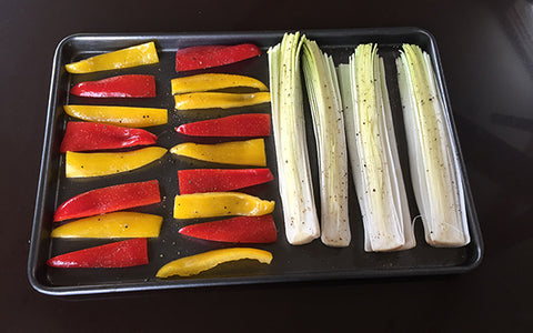 Image of Preheat oven to 400 degrees. Arrange leeks and peppers on a non stick sheet pan. Drizzle with ½ tablespoon of the oil and toss well. Season with salt and pepper. Roast, flipping once, until veggies are soft and starting to brown, about 20 minutes. Let cool for about 10 minutes