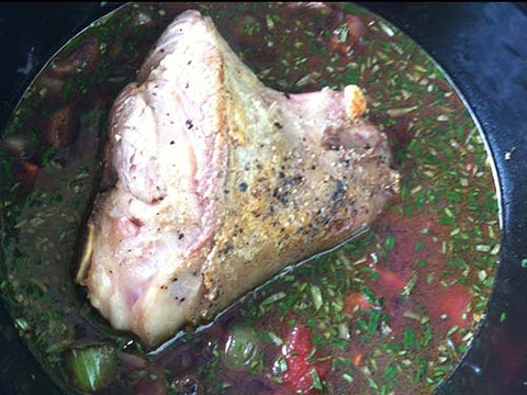 Image of lamb shanks with veggies and herbs in crockpot
