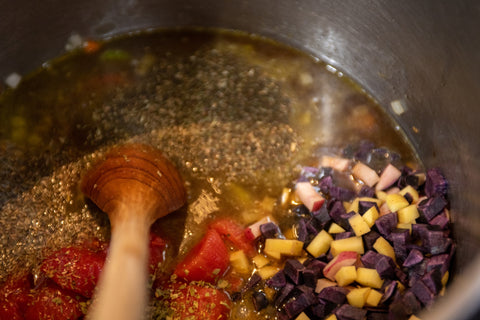 Image of adding spices and potatoes to soup base