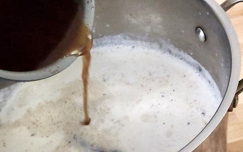 Image of pouring boiled chocolate into milk with cinnamon