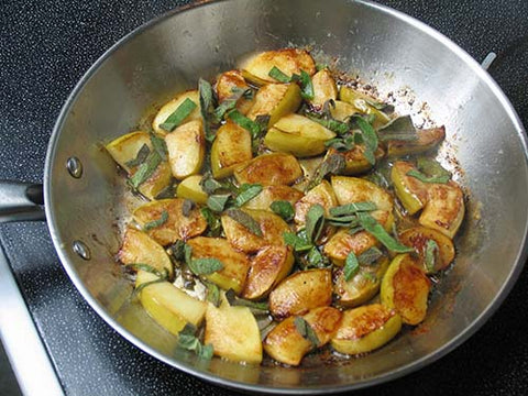 Image of heating potatoes and apples on a salute pan