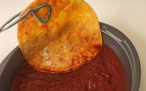 Image of tortilla dipped in sauce