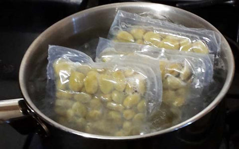 Image of While chicken is cooking in the oven, prepare fava beans per package directions. Once chicken pieces have been removed from baking pan, mix in drained fava beans while they are still warm