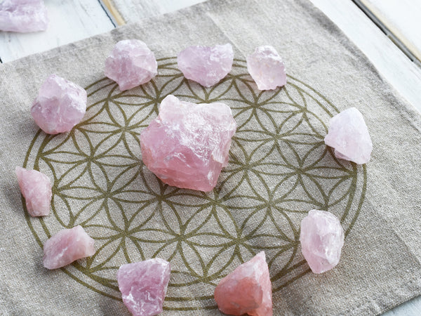 rough pieces of rose quartz crystal on a grid