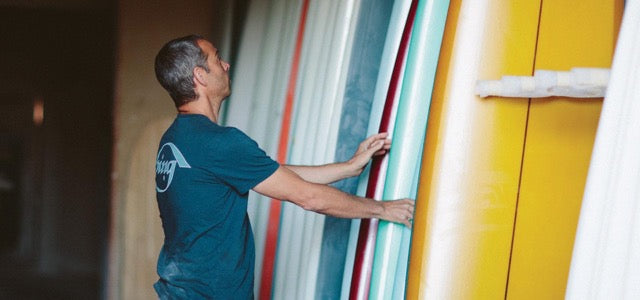 Matt Calvani inspecting surfboards