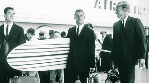 robert august, mike hyson, bruce brown in an airport with surfboard