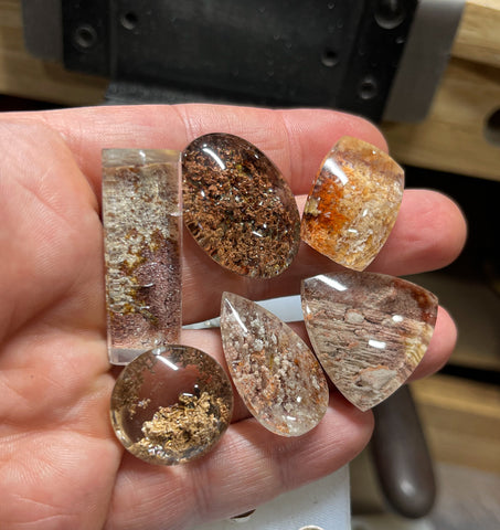 A group of garden quartz cabochons in a hand