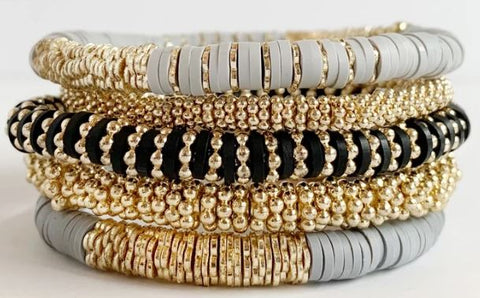 stack of 5 bracelets that are gray, black, and gold