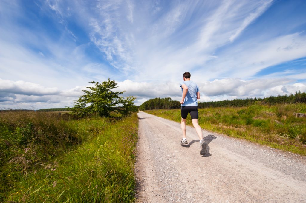 man running on a path in the countryside