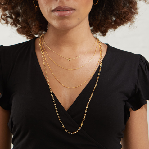 layered gold necklaces on model