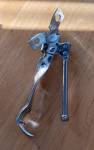 Metal, manual can opener with a bottle opener in it.