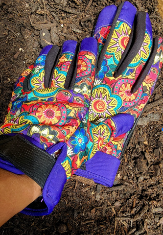Wrist-length gardening gloves with a feline design in bright reds, yellows and turquoise with bright purple accents on the finger tips and wrists.