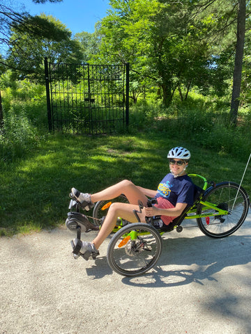 Ellie on her recumbent trike on a sunny day.