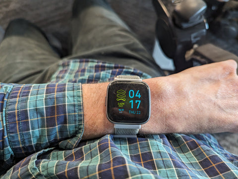 Smartwatch with square face and gray wristband on a person's wrist