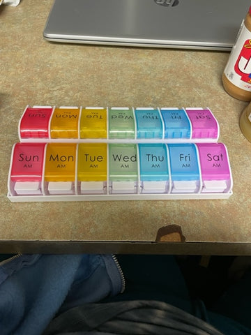 AM/PM Weekly Pill Organizer, each day with a different color lid, and white push buttons to open each day