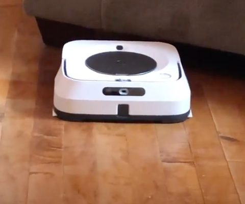 Small white iRobot Braava Mop with black accents on a hardwood floor.