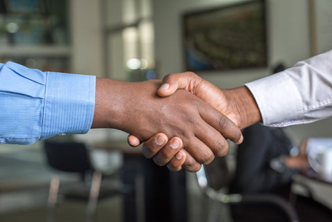 Two black people shaking hands close up