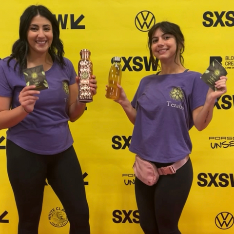 Tezahn bottles and infusion bags in front of the SXSW banner