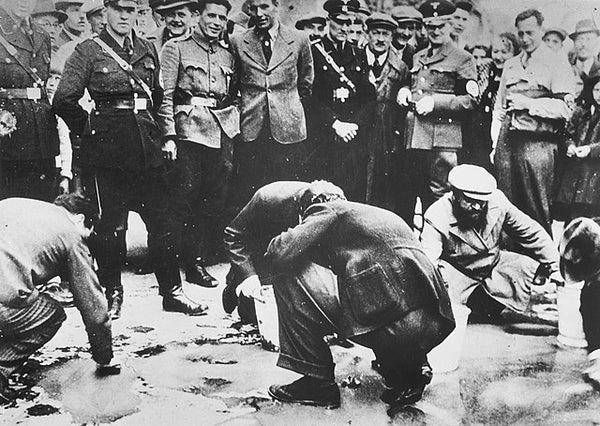 Austrian Nazis and local residents look on as Jews scrub the pavement.