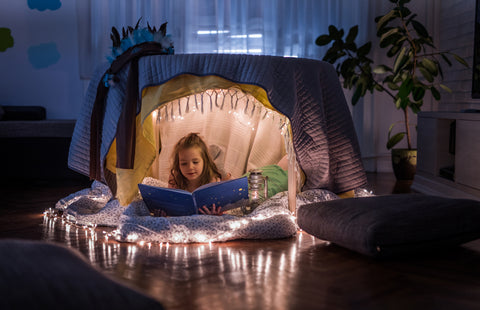 Child with a book in a reading den