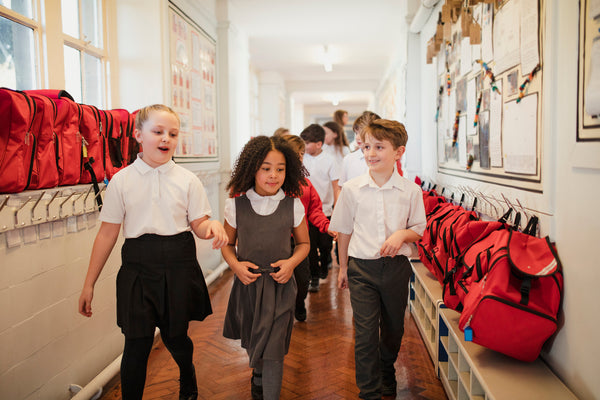 Three children walking down a school corridor