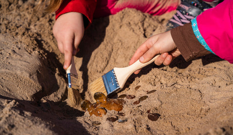 Child being an archaeologist with a paintbrush