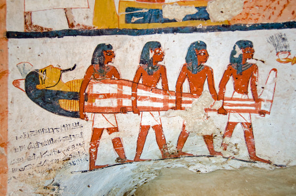 Mural of four ancient Egyptian men carrying a mummy