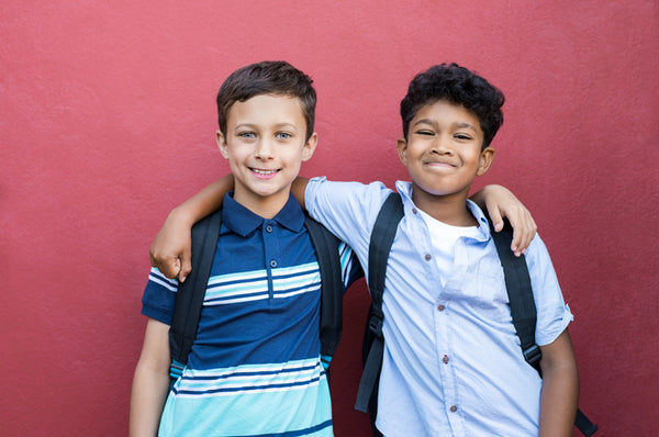 Two boys with their arms around each other's shoulders