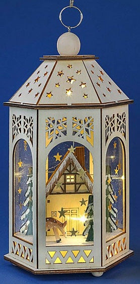 This wooden Pfaff Christmas lantern is 11.8 inches tall, powered by 2 AA batteries. The outside of the lantern is constructed from wooden panels with star, snowflake and triangular shaped laser cut patterns. Looking through the windows of lantern you see a traditional German Chalet house with snow-covered evergreen trees on each side of the house. A spotted deer is grazing in front of the house. The scene is lit up with a beautiful glow of light.