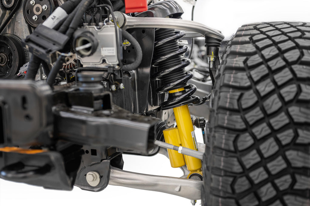 Closeup of the 2021 Ford Bronco independent front suspension featuring two forged aluminum alloy A-arms and available Bilstein long-travel position-sensitive dampers with end-stop control valves. 