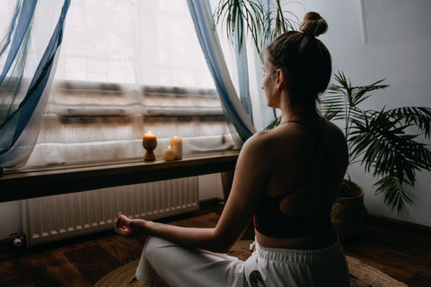 woman meditating in front of a window