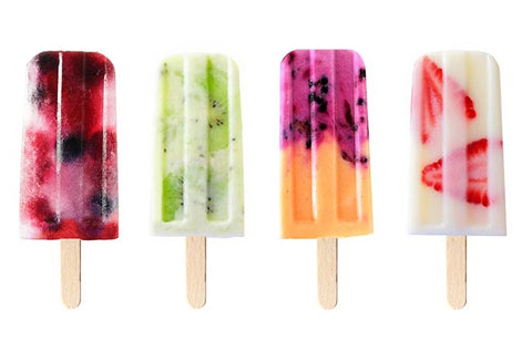 Four popsicles with different fruits and vegetables frozen into them.