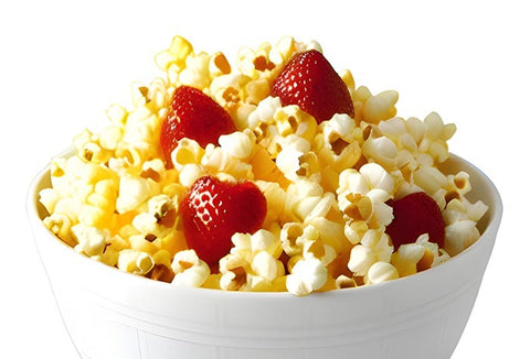A white bowl with buttery popcorn and strawberries mixed together.