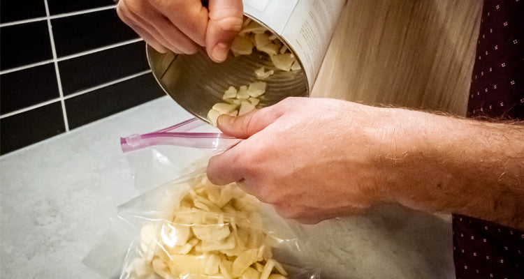 Pouring freeze-dried apples into a can